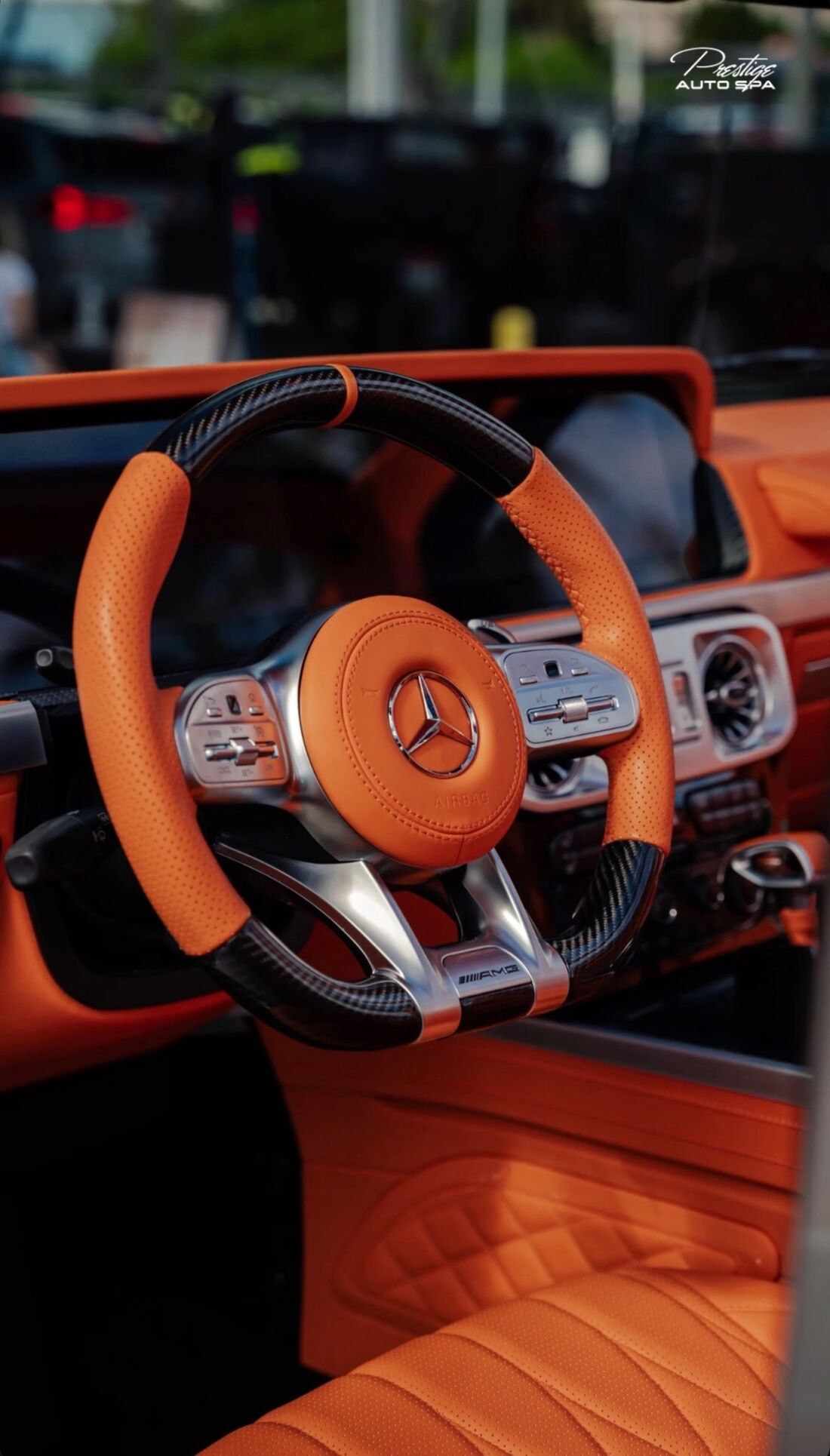 Orange leather and carbon fiber AMG steering wheel in a Mercedes G-Class